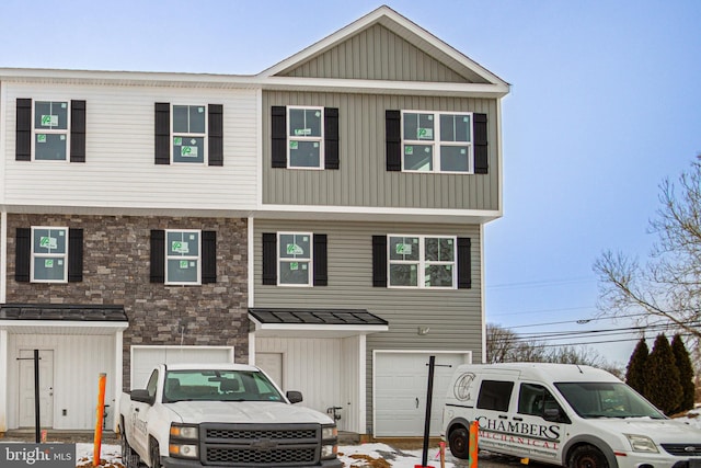 multi unit property with board and batten siding and a garage