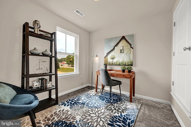 carpeted office space featuring visible vents and baseboards