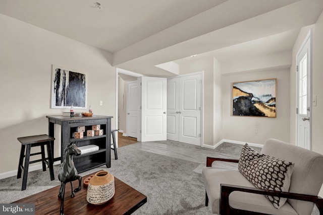 carpeted living area with baseboards