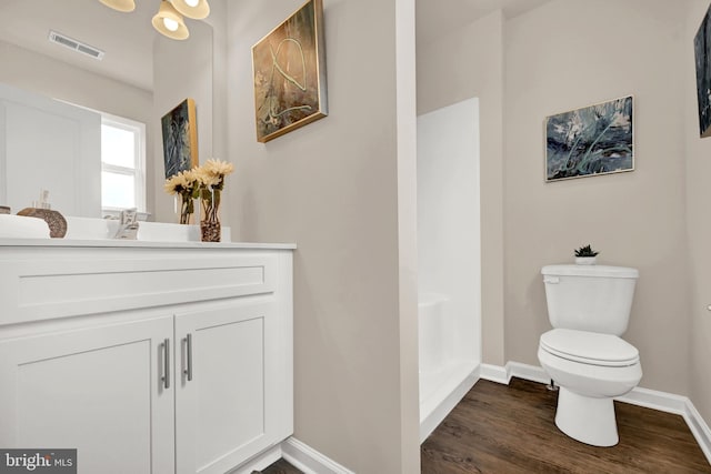 bathroom with visible vents, toilet, baseboards, and wood finished floors