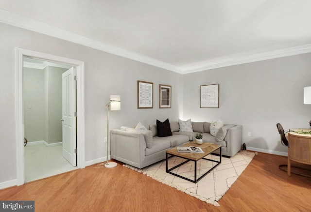 living room featuring baseboards, crown molding, and light wood finished floors