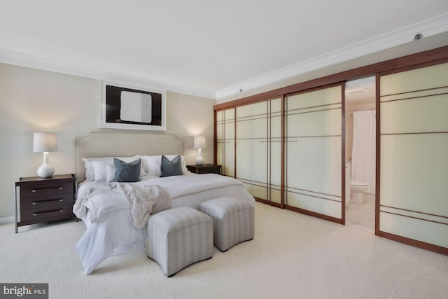 bedroom with light colored carpet, connected bathroom, and ornamental molding