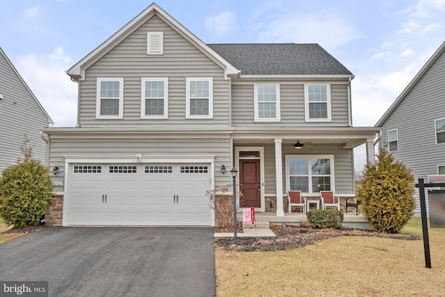 view of front of house with stone siding, covered porch, driveway, and a garage