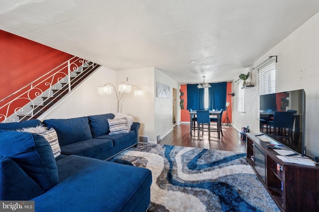 living area with a chandelier, baseboards, and wood finished floors