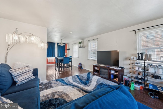 living room with baseboards, wood finished floors, and a chandelier