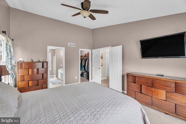 carpeted bedroom featuring visible vents, a closet, connected bathroom, baseboards, and a spacious closet