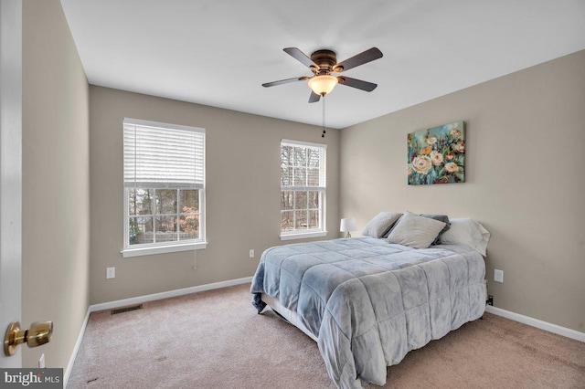 carpeted bedroom with baseboards, visible vents, and ceiling fan