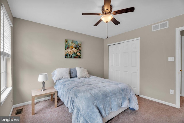 carpeted bedroom featuring a closet, visible vents, ceiling fan, and baseboards