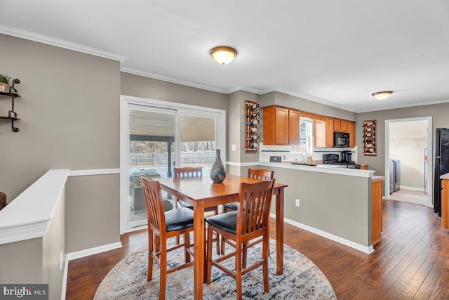 dining area featuring dark wood-style floors, baseboards, and ornamental molding