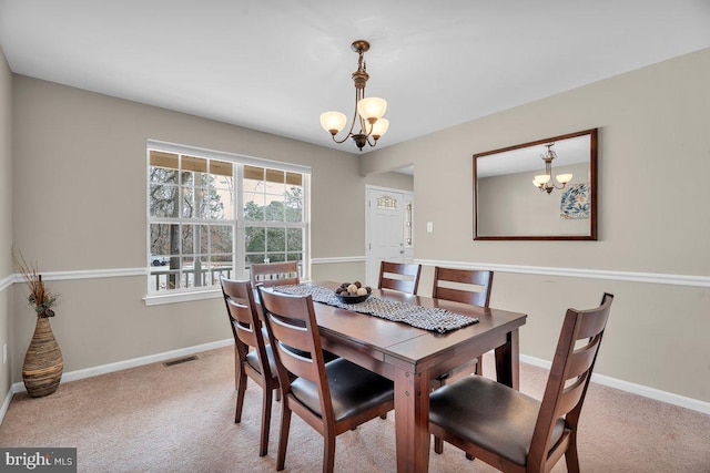 carpeted dining area with a notable chandelier, baseboards, and visible vents