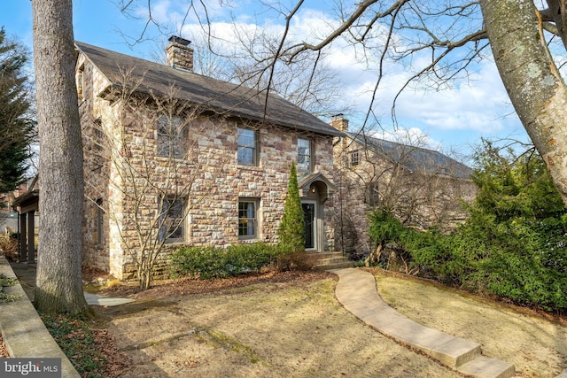 view of front of home featuring stone siding and a chimney