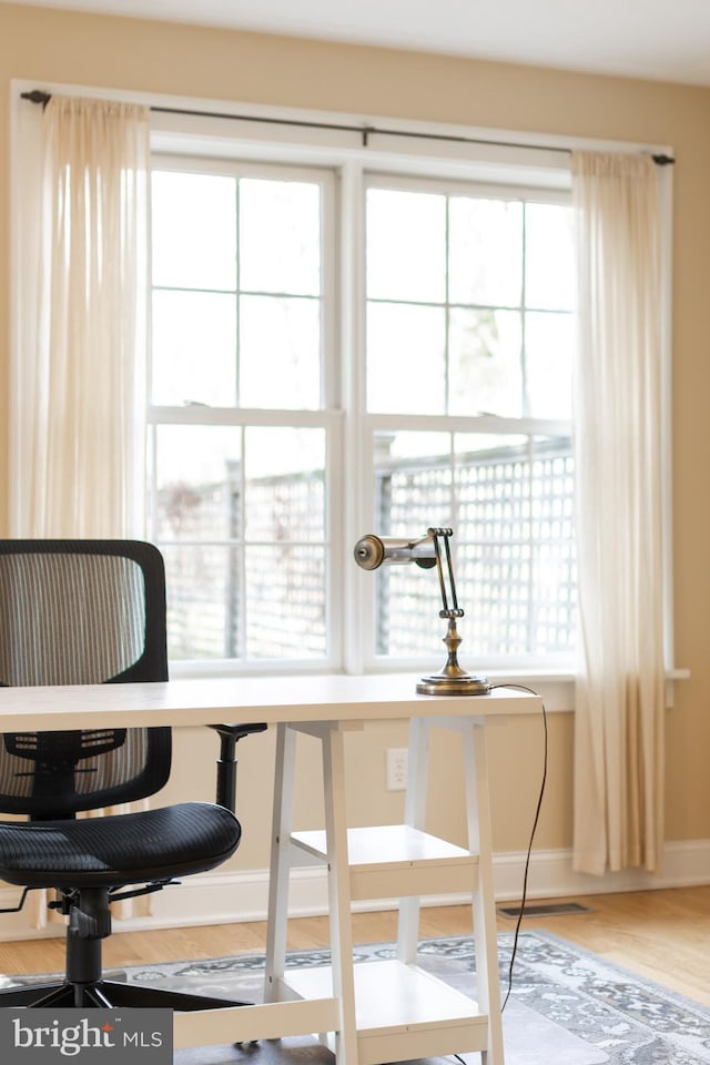 office featuring visible vents, baseboards, and wood finished floors