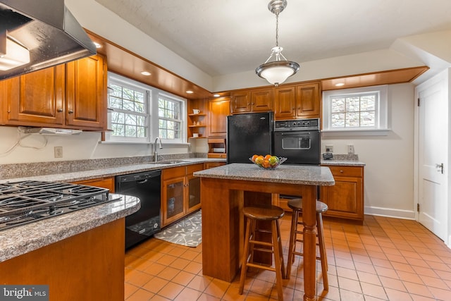 kitchen with a healthy amount of sunlight, extractor fan, brown cabinets, black appliances, and a sink