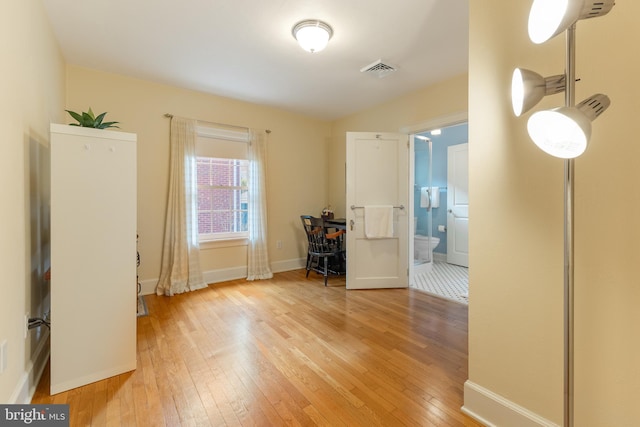 interior space with light wood-style floors, visible vents, and baseboards