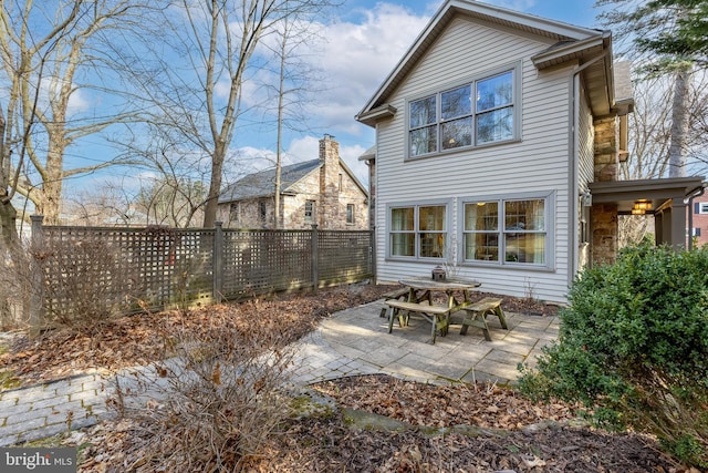 rear view of property featuring a fenced backyard and a patio