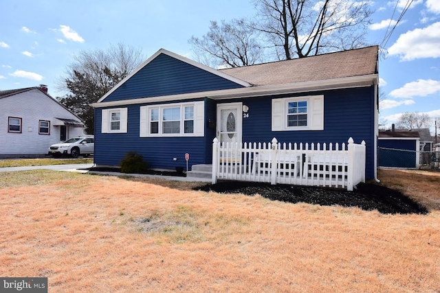 view of front facade featuring a front yard and fence