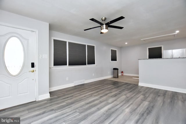 entrance foyer featuring wood finished floors, a ceiling fan, visible vents, and baseboards