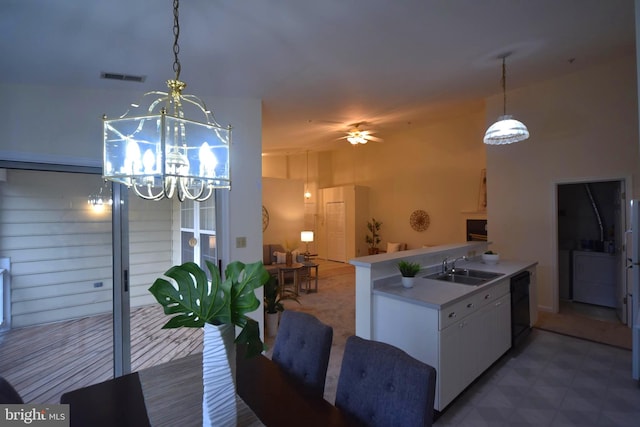 kitchen with visible vents, a sink, pendant lighting, dishwasher, and ceiling fan with notable chandelier