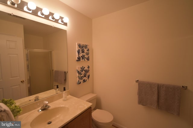 bathroom with a stall shower, toilet, and vanity