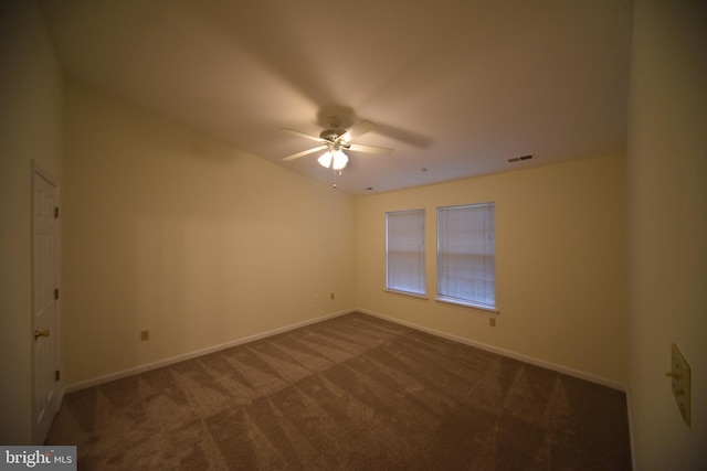 spare room with carpet flooring, visible vents, baseboards, and ceiling fan