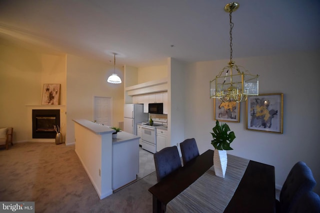 dining room with baseboards, a fireplace, vaulted ceiling, light carpet, and a notable chandelier