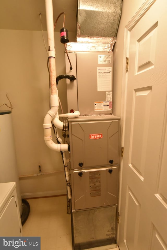 utility room featuring heating unit and water heater