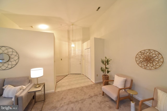 sitting room with baseboards, carpet floors, and a towering ceiling