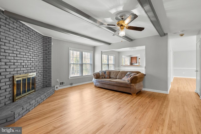 living area with light wood finished floors, visible vents, baseboards, ceiling fan, and beamed ceiling