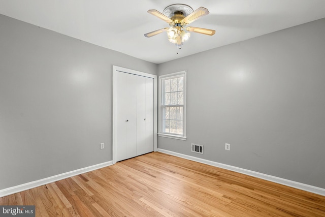 unfurnished bedroom with visible vents, baseboards, light wood-style flooring, a closet, and a ceiling fan