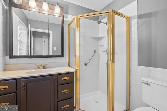 bathroom with a stall shower, toilet, and vanity