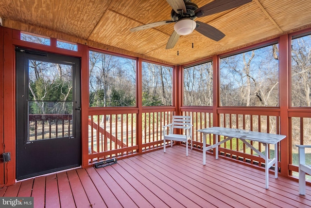 unfurnished sunroom with wood ceiling and a ceiling fan