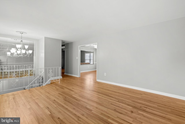 interior space with baseboards, an inviting chandelier, and light wood finished floors