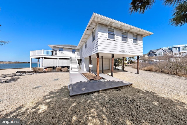 rear view of house featuring stairway and a carport