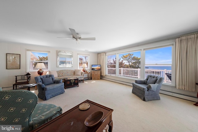 living area with a baseboard heating unit, carpet floors, and a ceiling fan