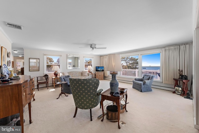 living area featuring visible vents, plenty of natural light, light colored carpet, and a baseboard heating unit