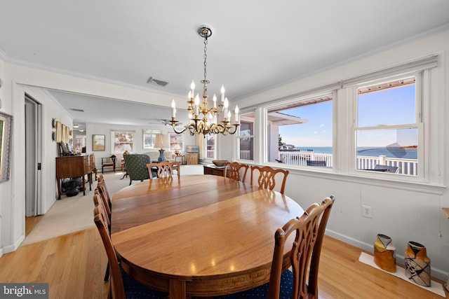 dining space featuring visible vents, light wood-style floors, a chandelier, and ornamental molding