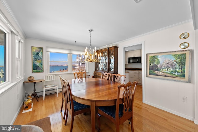 dining room with baseboard heating, an inviting chandelier, light wood-style flooring, and ornamental molding