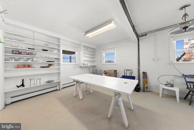 office featuring concrete block wall, concrete flooring, and a baseboard radiator