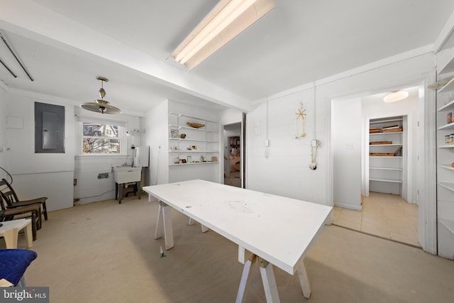 dining space featuring beam ceiling, electric panel, and light colored carpet