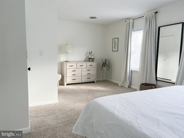 carpeted bedroom with visible vents and baseboards