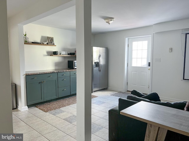 interior space featuring light tile patterned floors, appliances with stainless steel finishes, baseboards, and open shelves