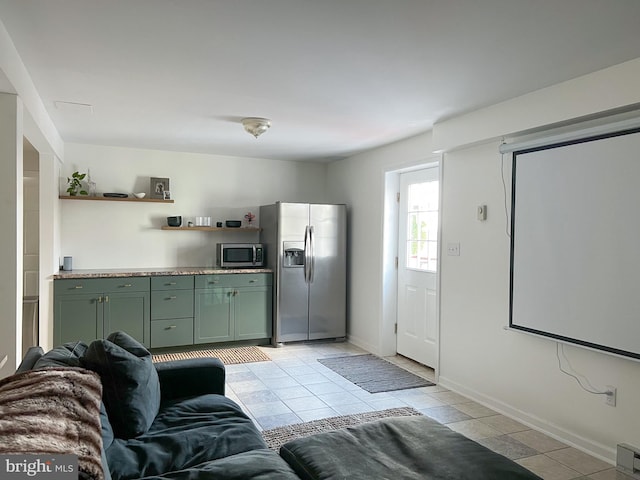 kitchen with light tile patterned flooring, appliances with stainless steel finishes, open shelves, and green cabinetry