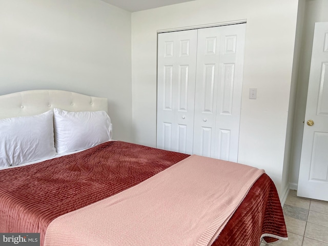 bedroom with light tile patterned floors and a closet