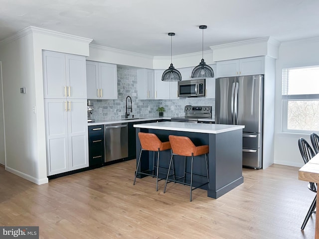 kitchen featuring light wood-style flooring, a sink, a kitchen breakfast bar, a kitchen island, and stainless steel appliances