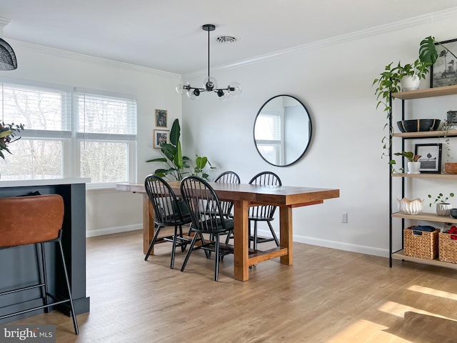 dining area featuring visible vents, a notable chandelier, light wood-style flooring, and crown molding