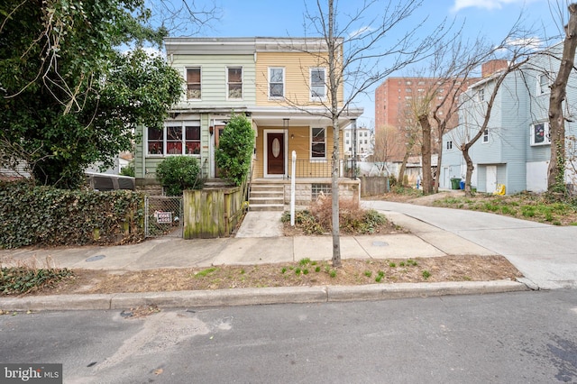 view of front of home with a fenced front yard and covered porch