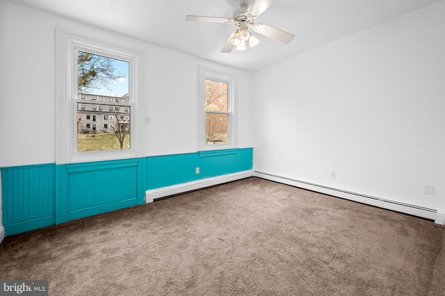 spare room with baseboard heating, a wainscoted wall, and carpet floors