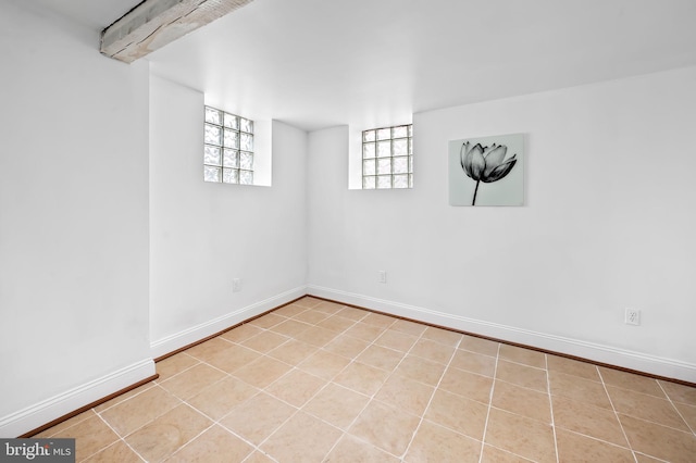 basement featuring tile patterned floors and baseboards