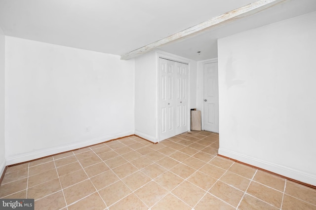 unfurnished room with light tile patterned floors and baseboards