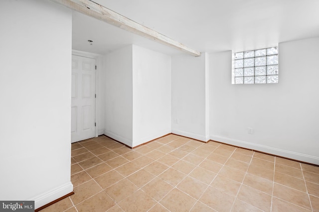 empty room featuring light tile patterned floors and baseboards